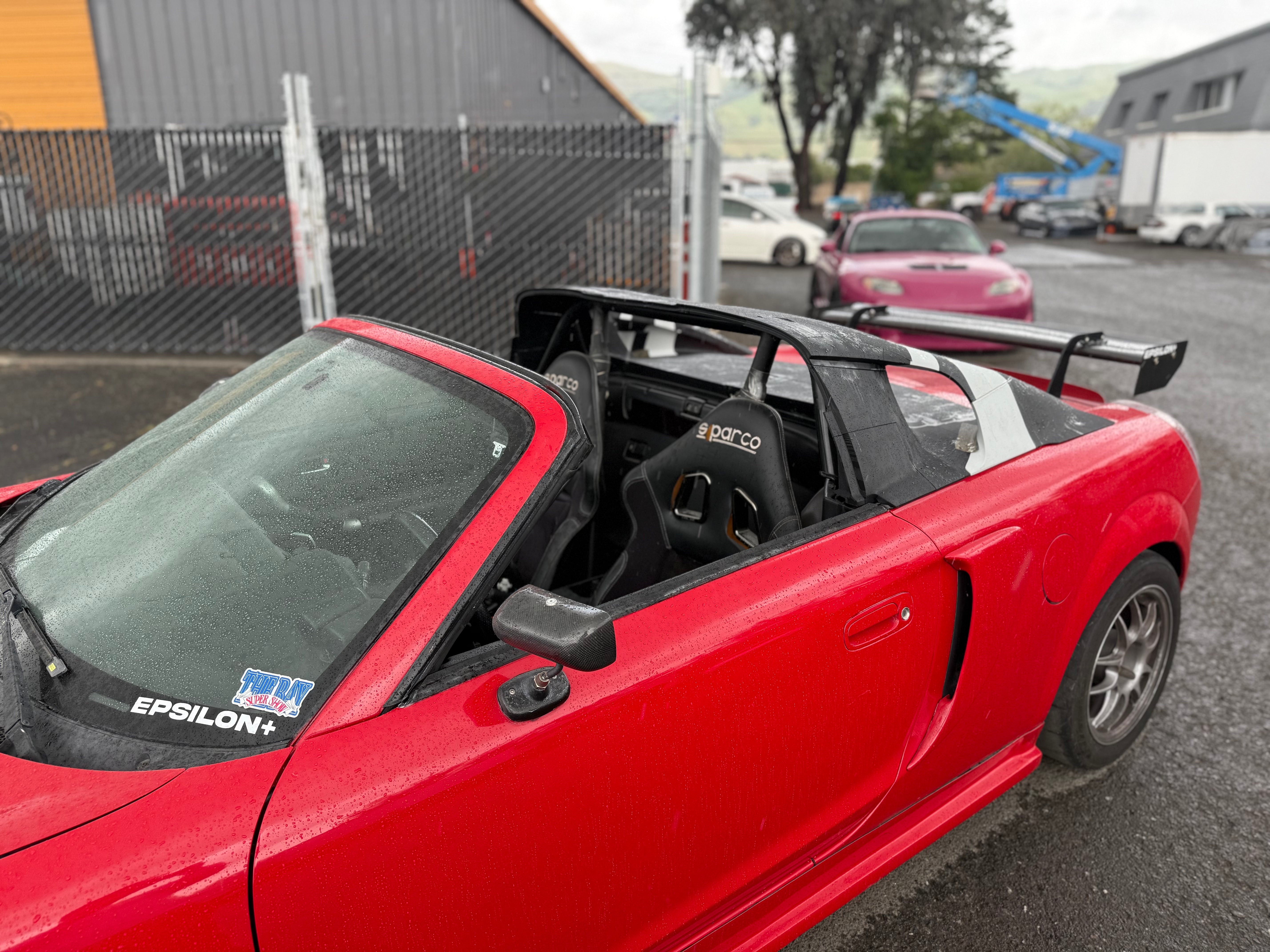 Red Toyota MR2 Spyder with the hardtop removed showing the roll bar