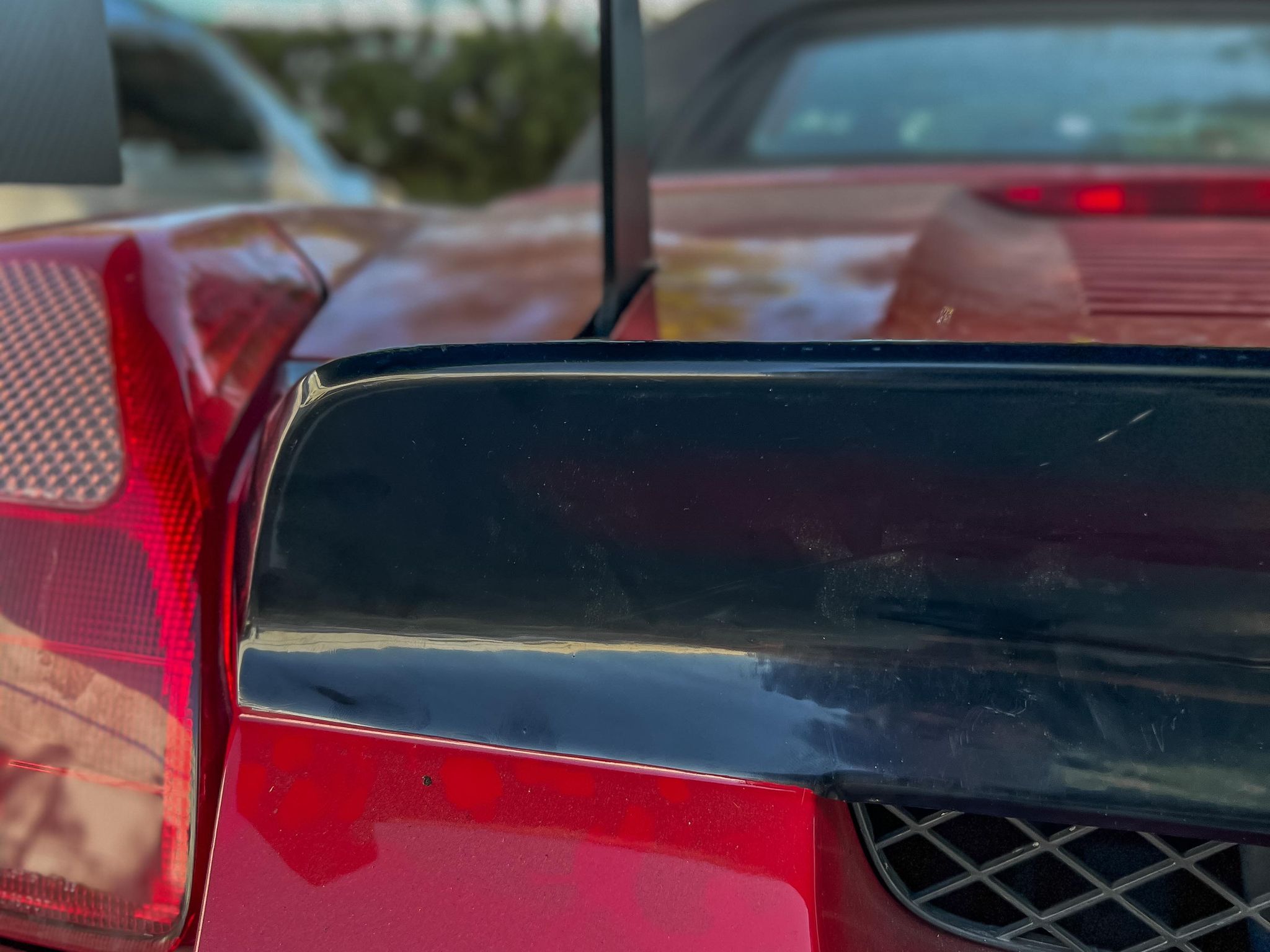 Close-up of the duckbill spoiler mounted on the rear deck of a red MR2 Spyder