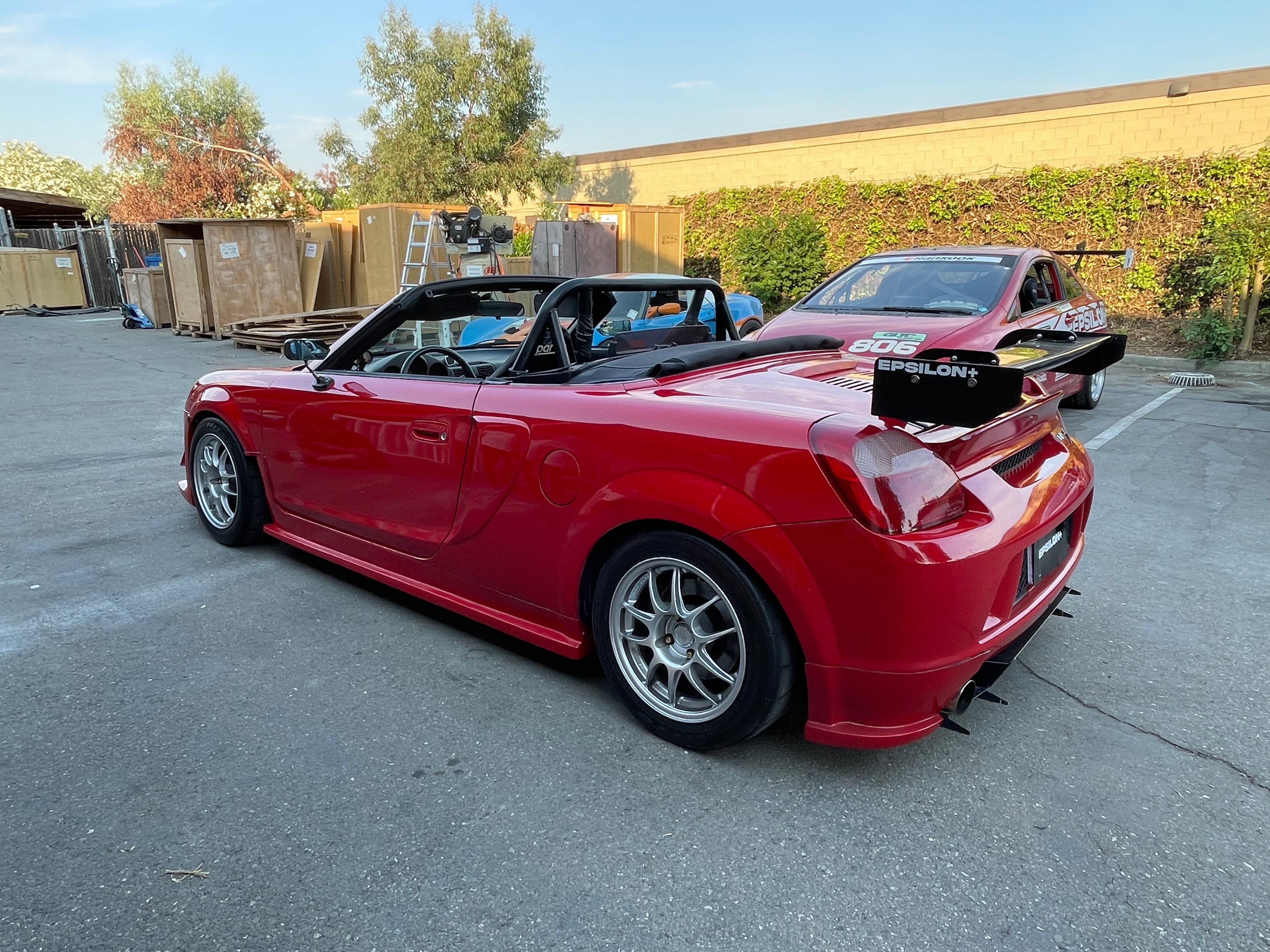 Rear three-quarter view of a red MR2 Spyder with the side skirt and fender combo