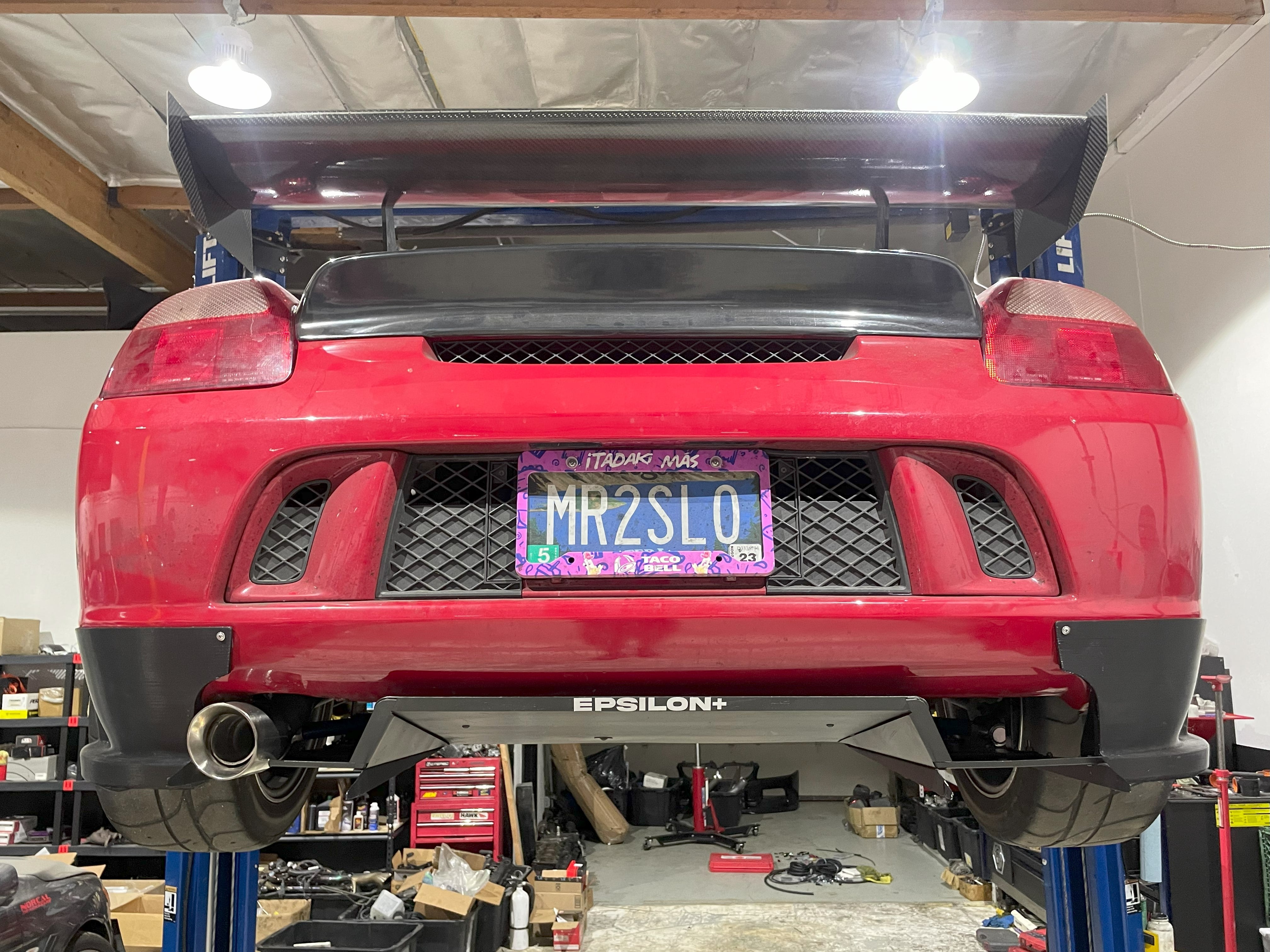 Rear view of a red MR2 Spyder on a lift with the V1+ diffuser installed