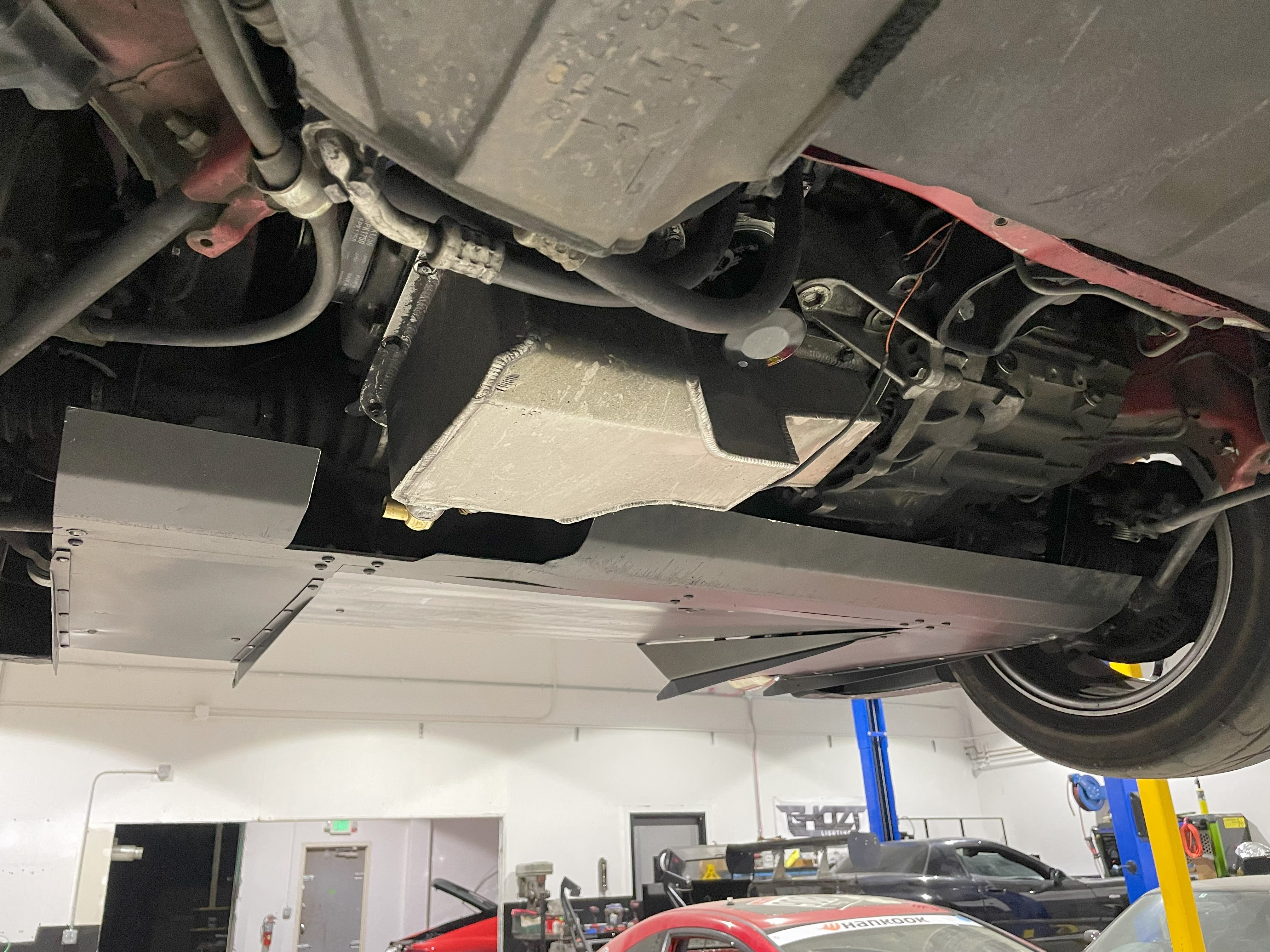 Side underbody view of a Toyota MR2 Spyder on a lift with the V1+ diffuser fitted