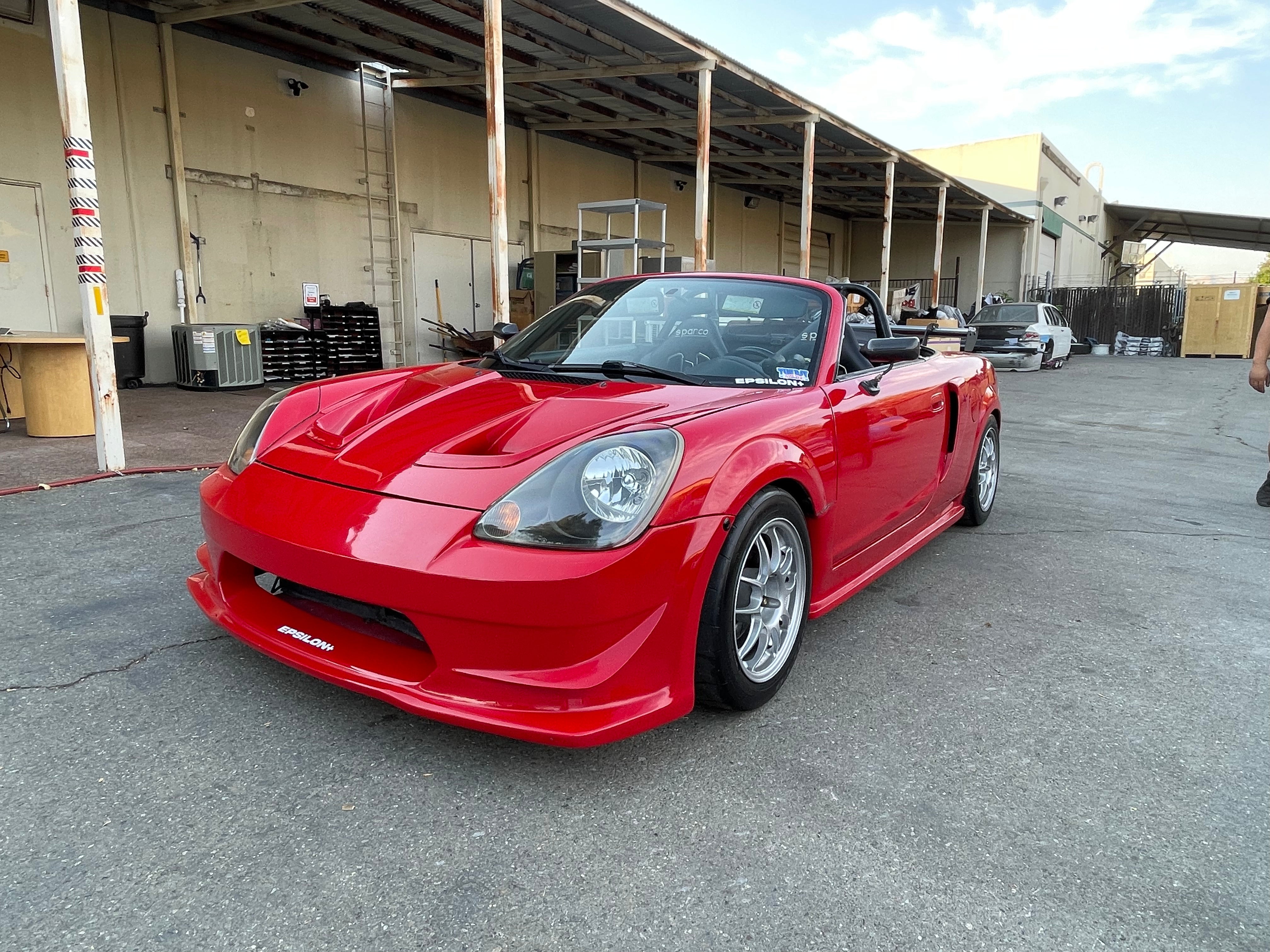 Front three-quarter view of a red Toyota MR2 Spyder with the Epsilon+ front bumper
