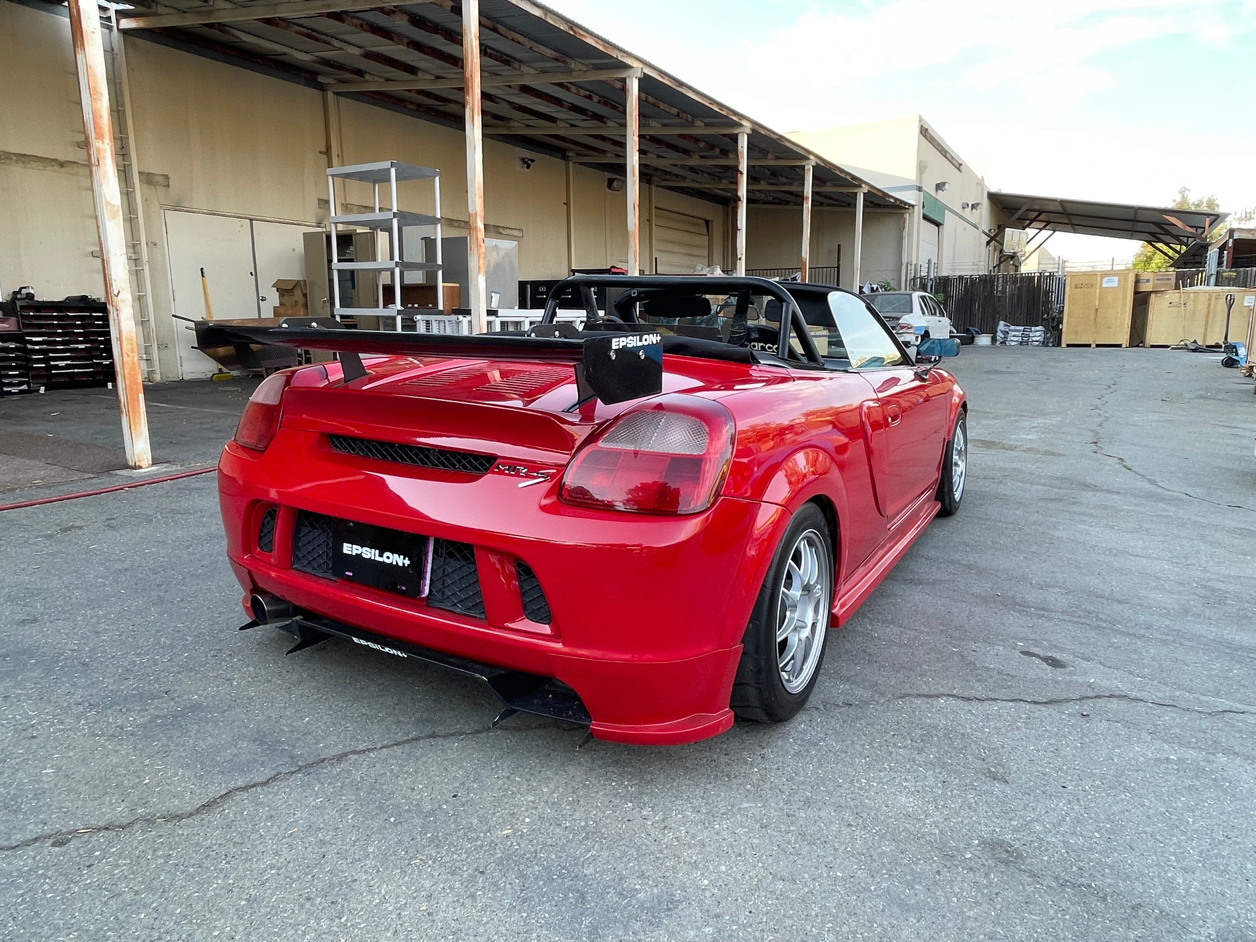 Rear three-quarter view of a red Toyota MR2 Spyder with the Epsilon+ rear wing