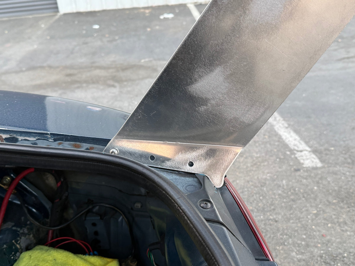 TC wing upright bolted to the NB Miata body beside the open trunk, showing the mounting point