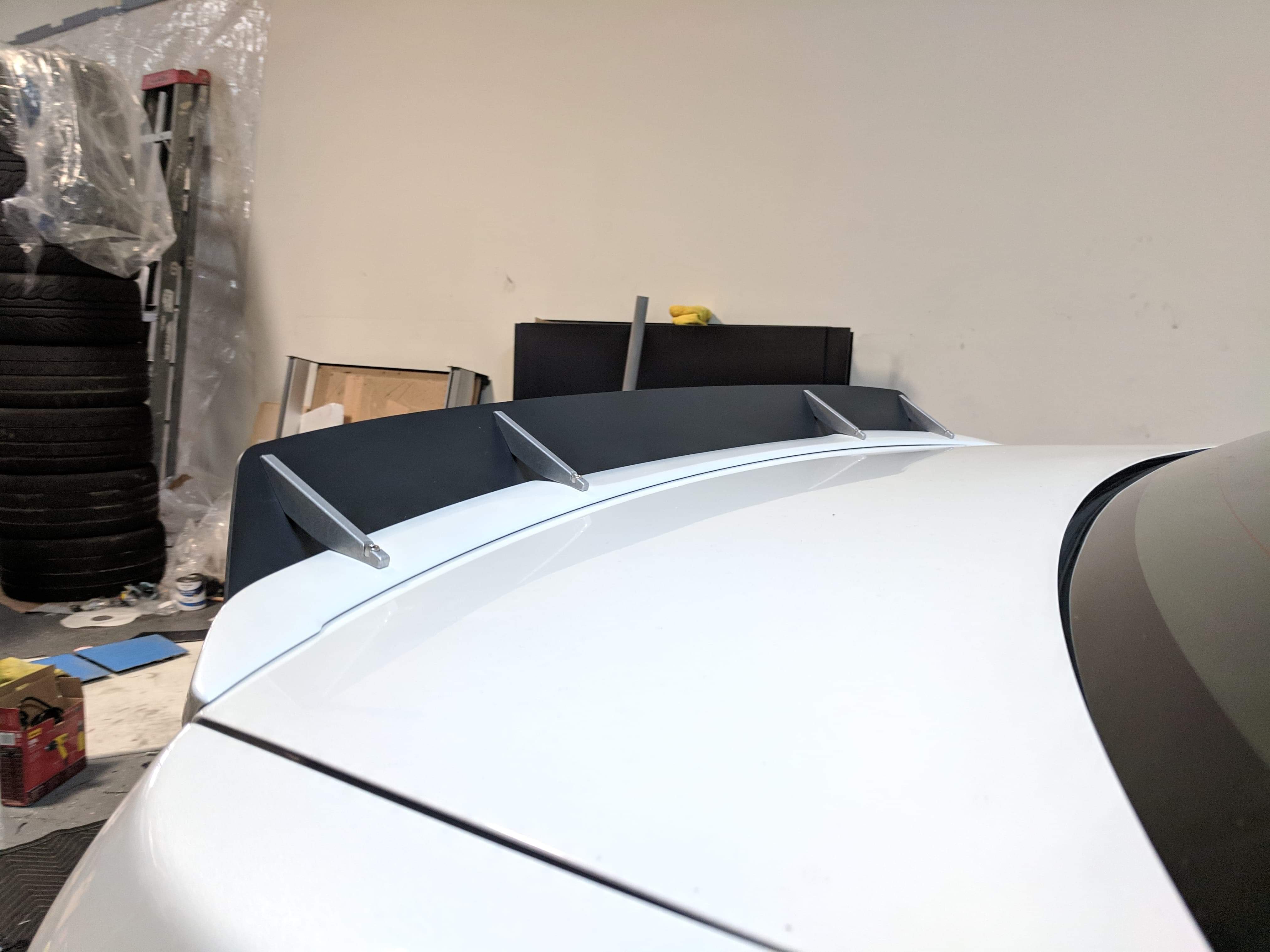 Close-up of the spoiler extension mounted on a white WRX VA roofline