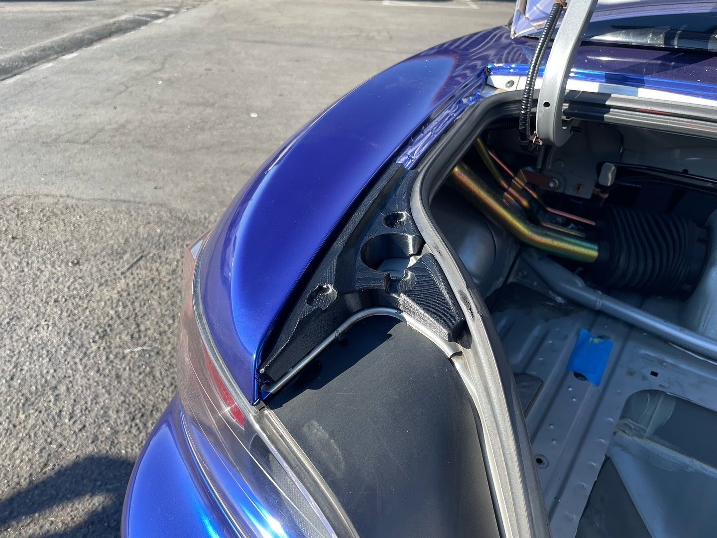 Close-up of the GT wing mounting hardware inside a blue S2000 trunk