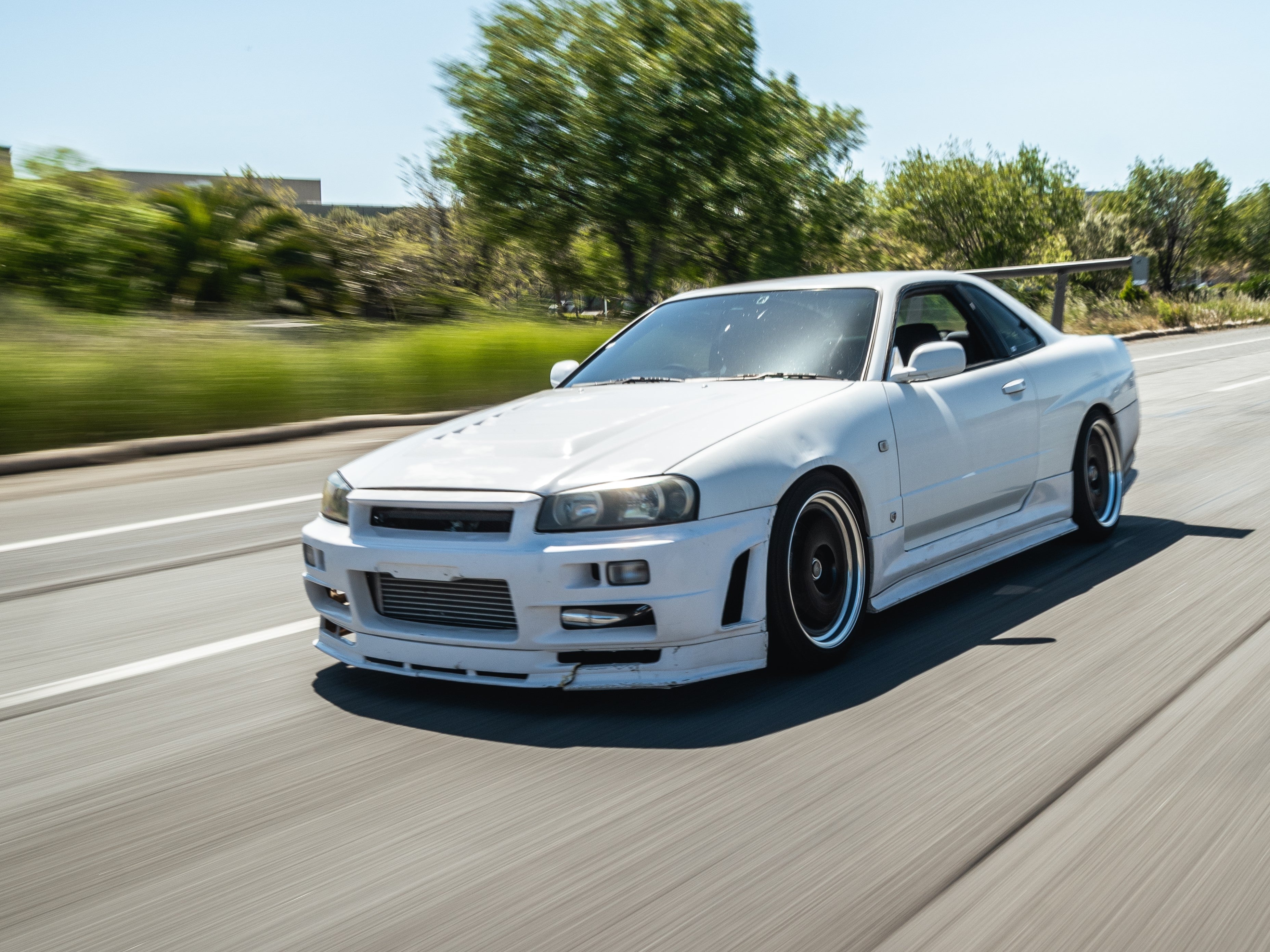 Nissan Skyline R34 Coupe with Epsilon+ GT wing, rolling shot with motion blur