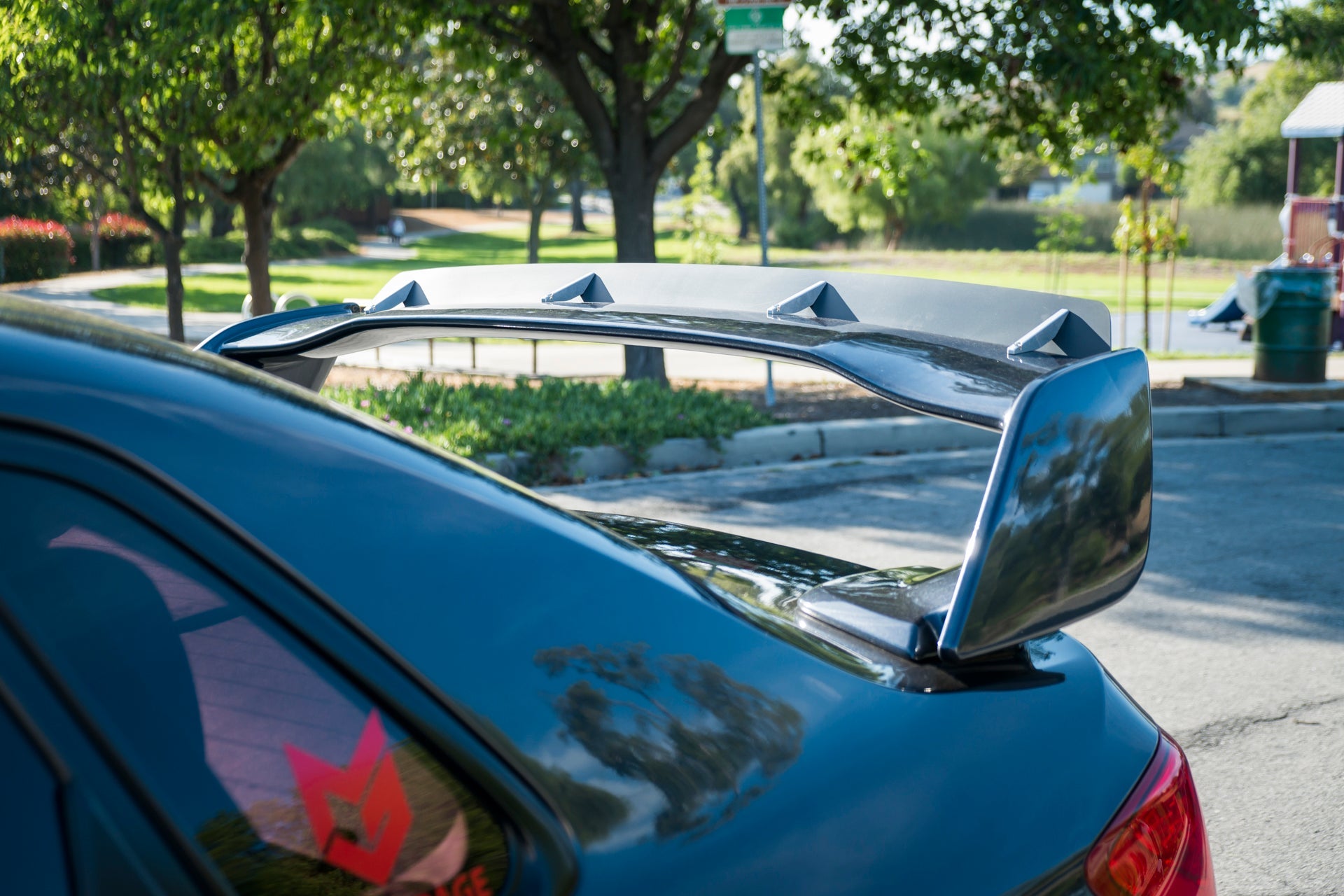 Close-up of the spoiler extension mounted on a gray STI Sedan trunk wing