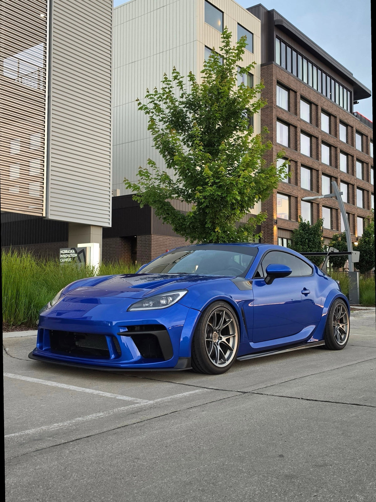 Front three-quarter view of a blue Subaru BRZ ZN8 with an Epsilon+ GT wing on swan neck mounts