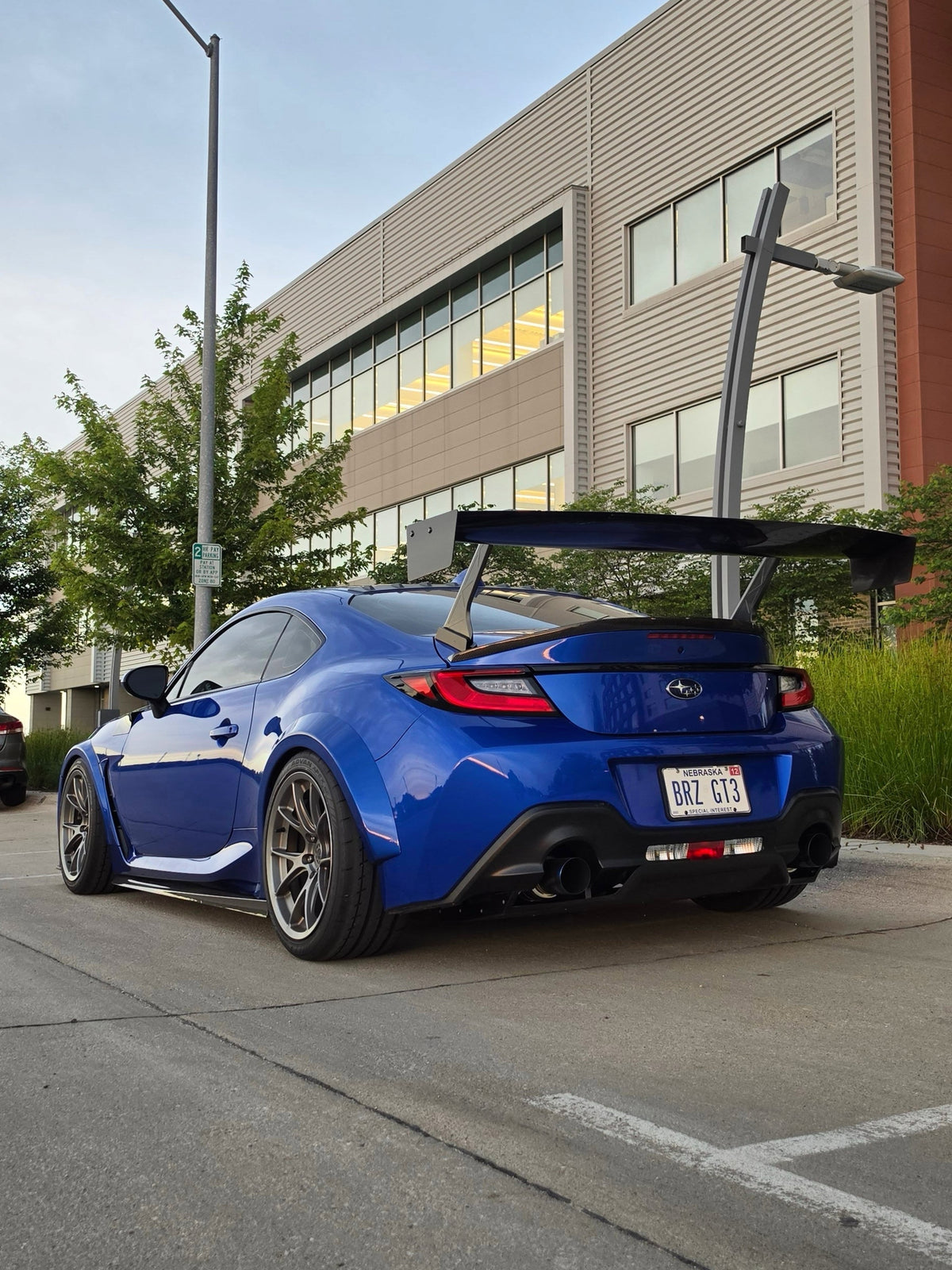 Rear three-quarter view of a blue Subaru BRZ ZN8 with an Epsilon+ GT wing on swan neck mounts