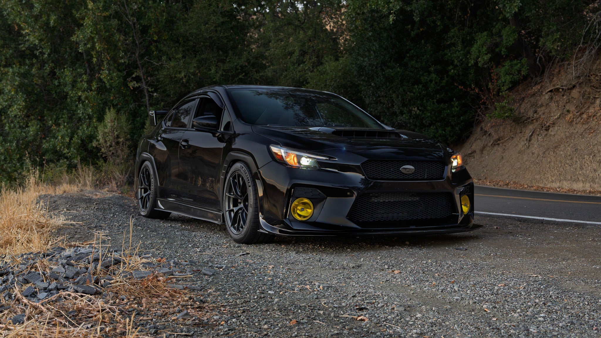 Front three-quarter view of a black Subaru WRX VB with prototype front bumper on a gravel road