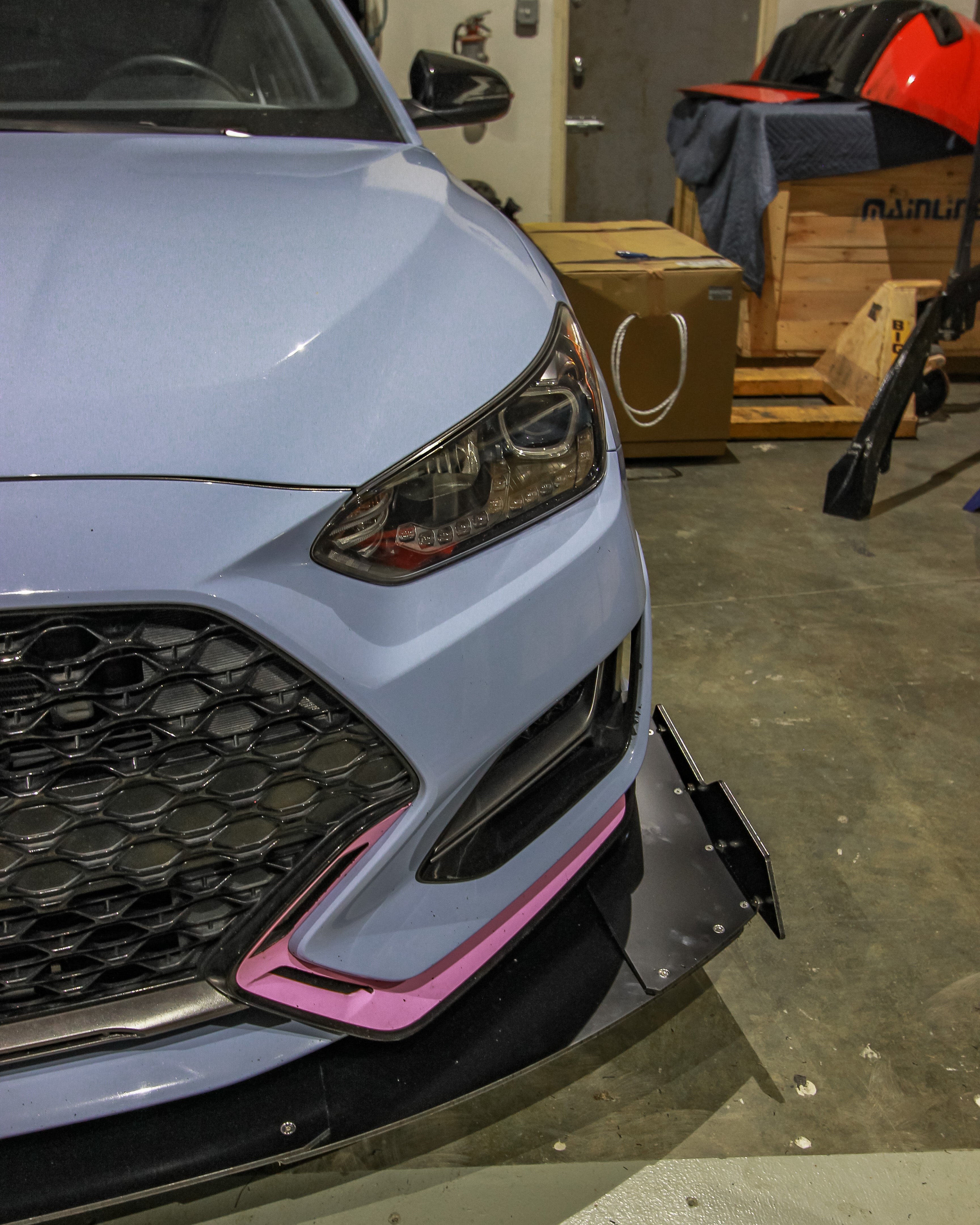 Corner detail of the V2 front splitter and side extension on a Veloster N