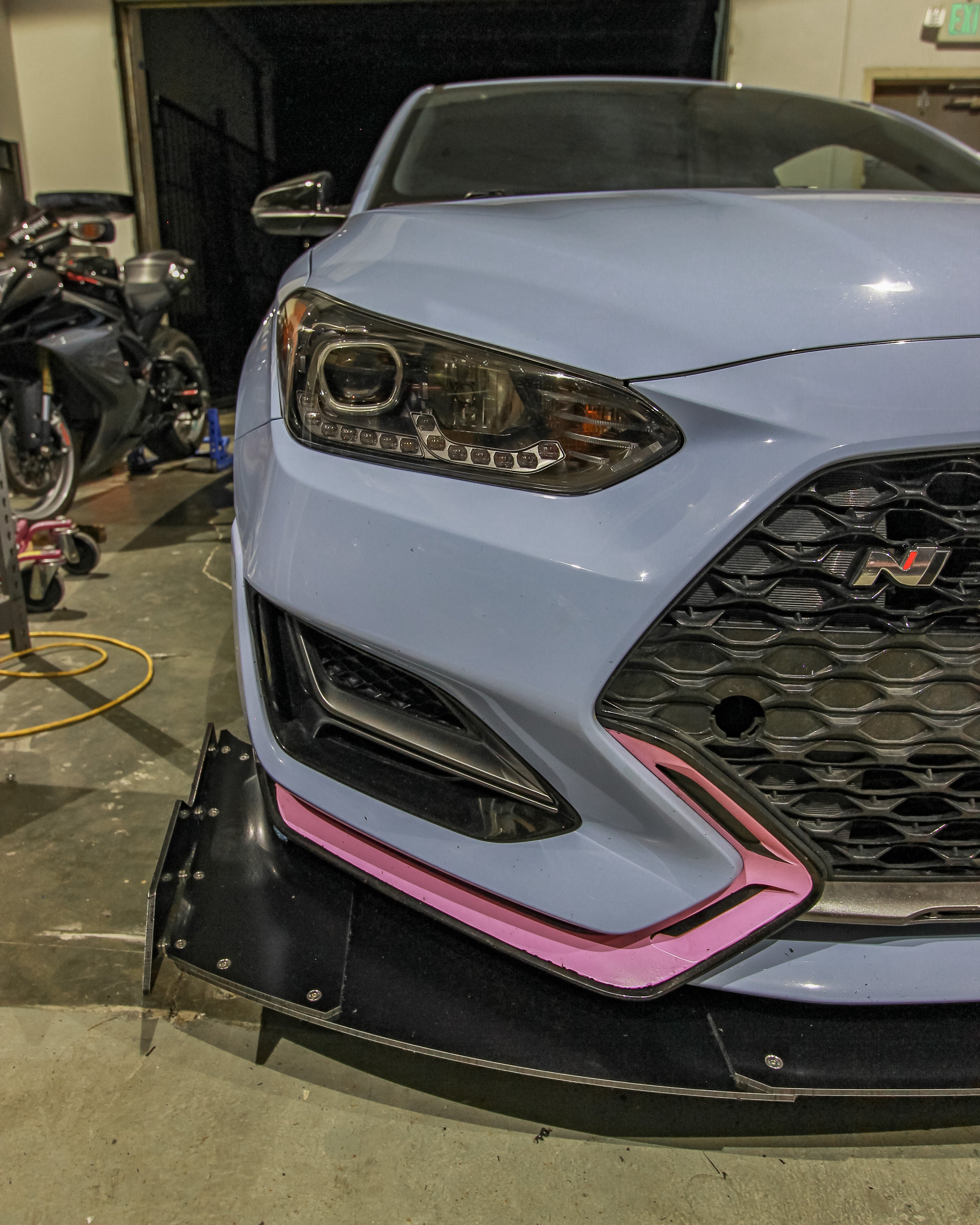 Close-up front three-quarter view of the V2 front splitter on a Veloster N