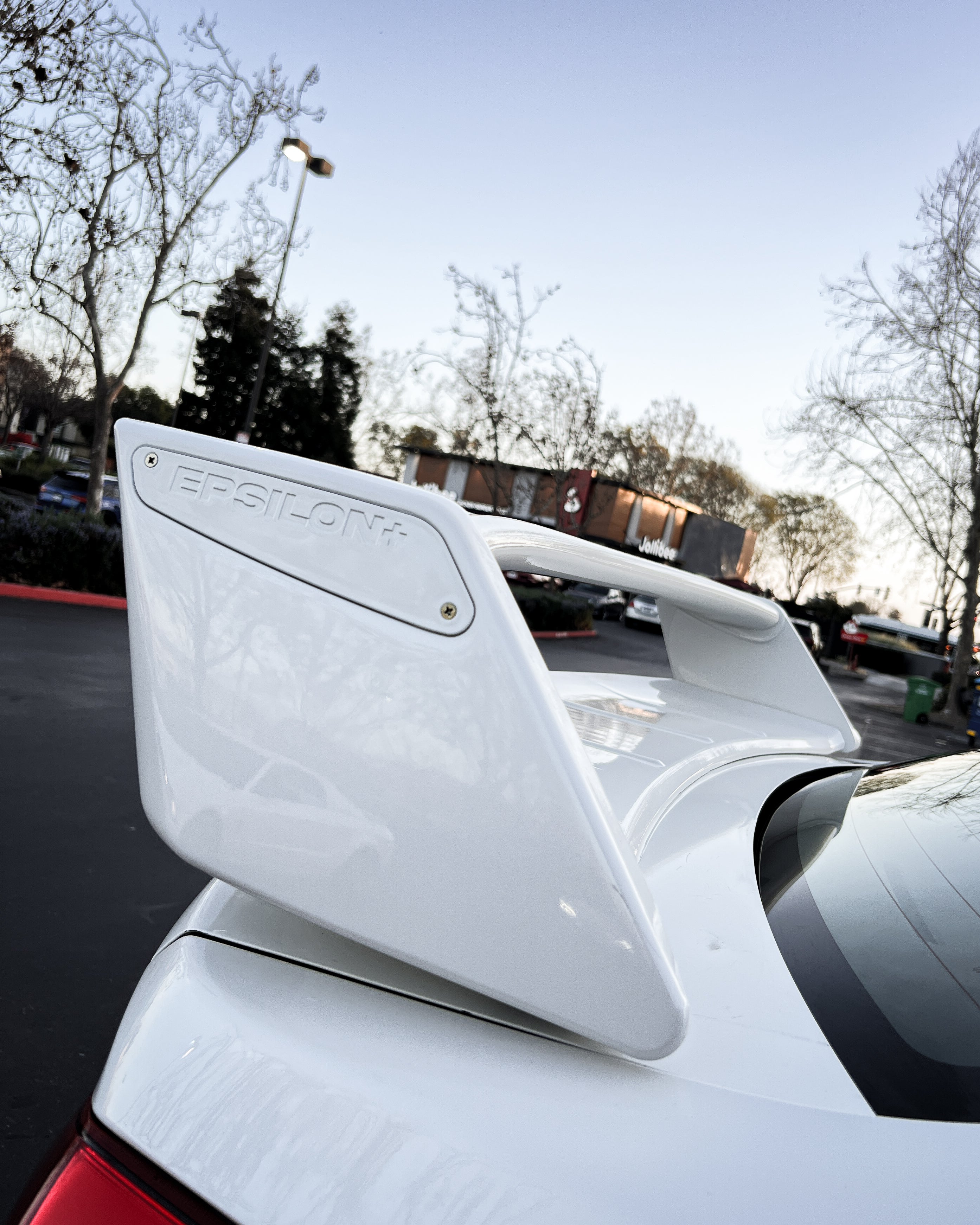 Close-up of the WRC wing upright mounted to the trunk of a white Subaru WRX VA