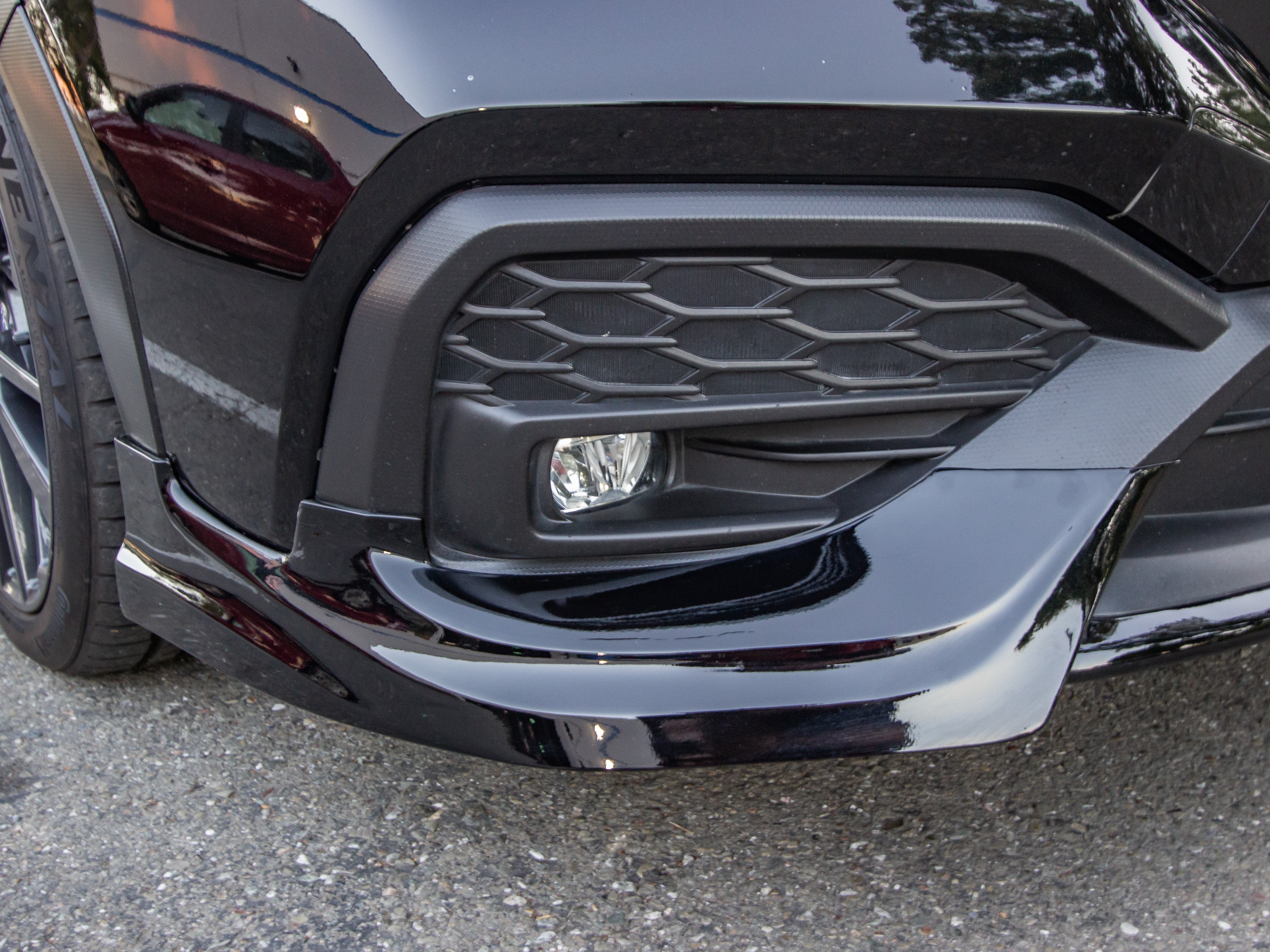 Close-up of the front lip corner and lower bumper on a black Subaru WRX VB
