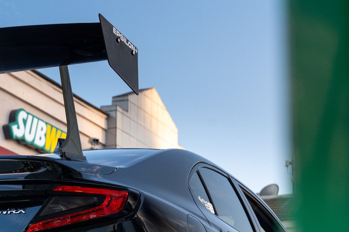 Low-angle view of the GT wing upright beside the taillight of a Subaru WRX VB
