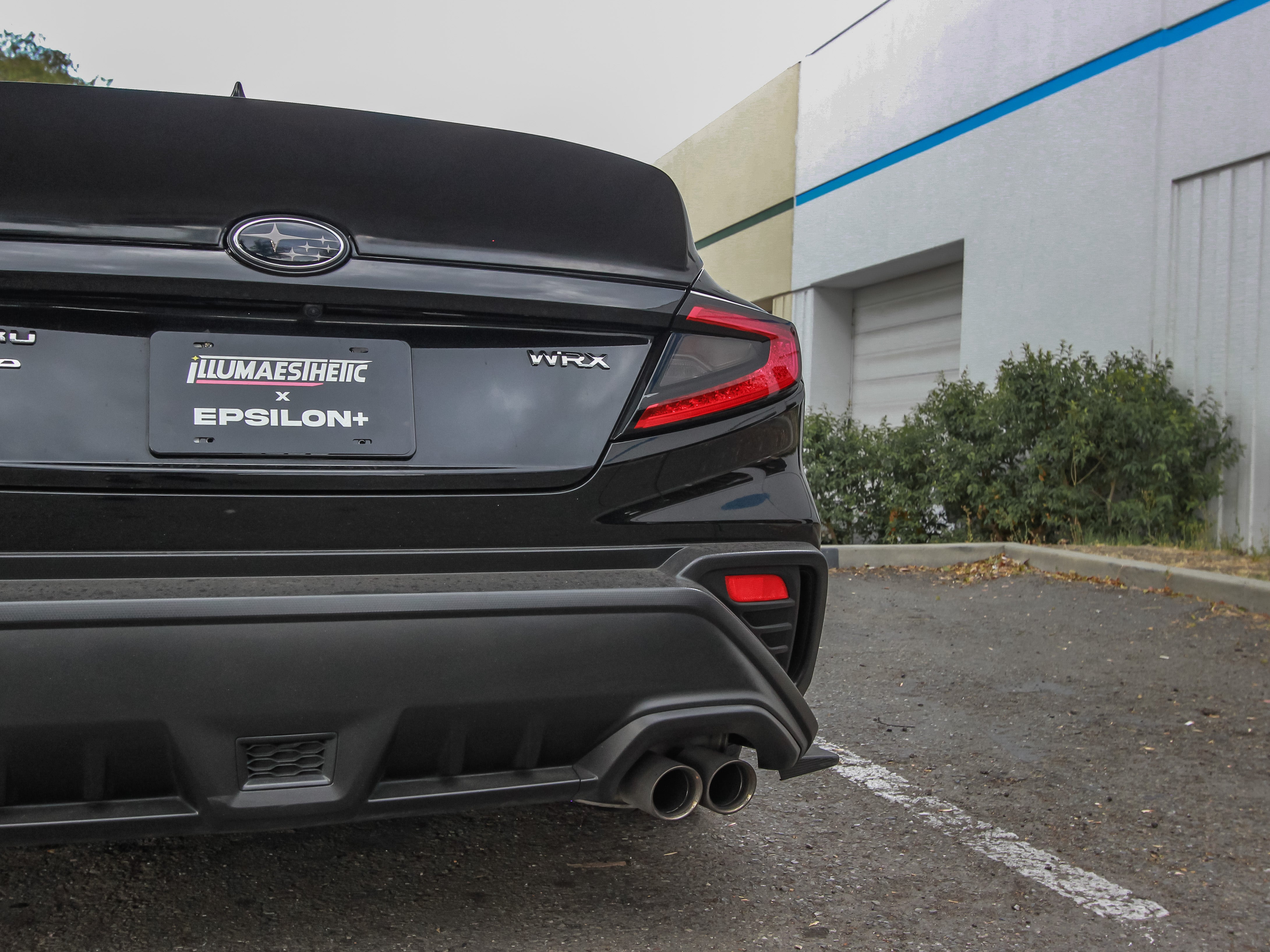 Close rear view of the duckbill spoiler and trunk lid on a black Subaru WRX VB