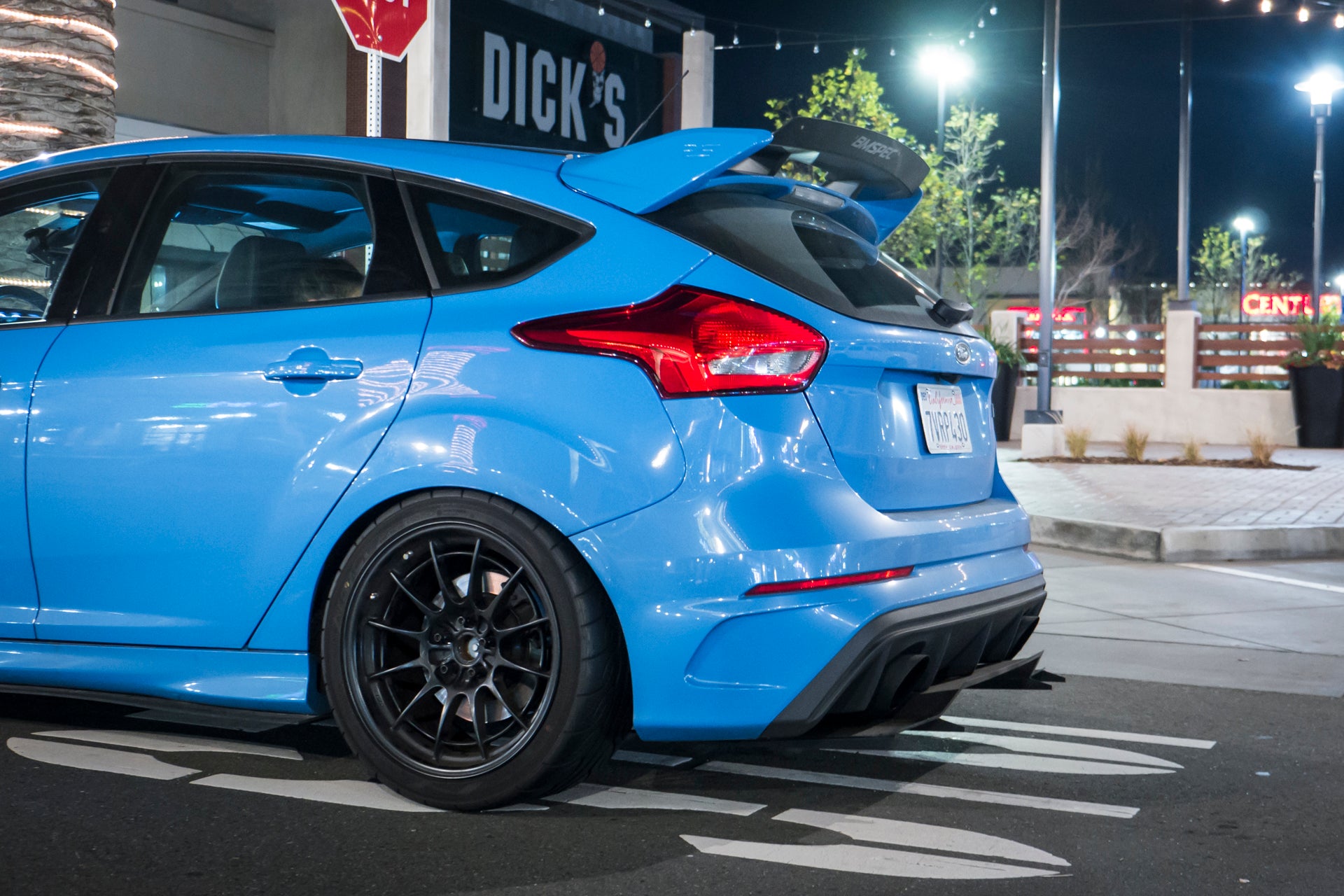 Rear three-quarter view of a blue Focus RS at night showing the V1+ diffuser under the rear bumper