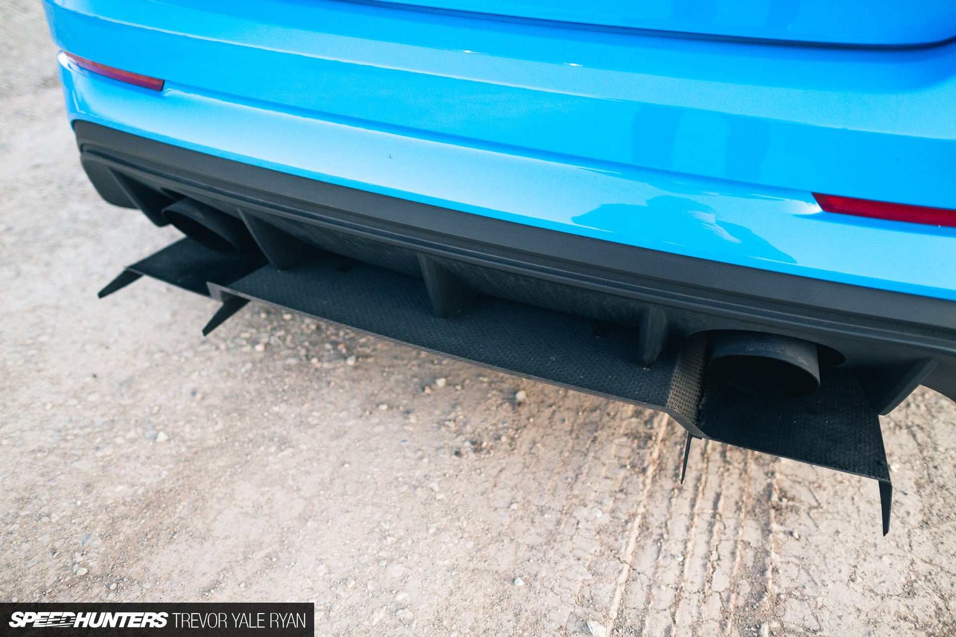 Close-up of the V1+ diffuser fins mounted under a blue Ford Focus RS