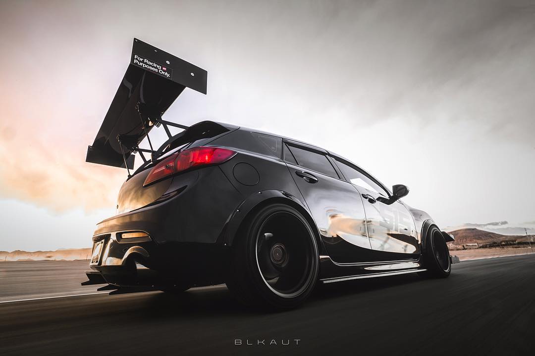 Low-angle rear three-quarter shot of a black Mazdaspeed3 Gen2 with V1+ diffuser and GT wing